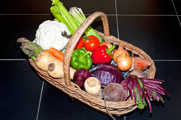 黒いタイル張りの床に籐のバスケットのすべての色の新鮮な市場の野菜 - asparagus vegetable market basket ストックフォトと画像