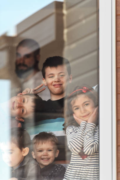 istock Quarantined family photographed through window 1224149012