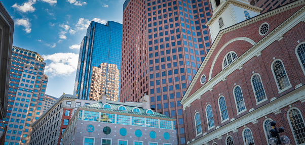Panoramic image of conventional and modern buildings with cloudy blue sky backgrounds taken from the Faneuil Hall Market Place in Quincy  Market in Boston MA