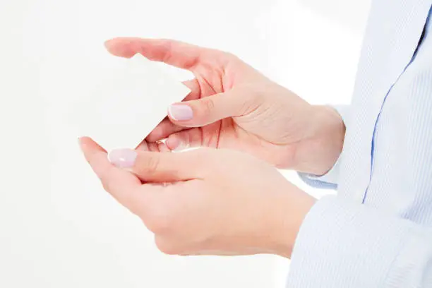 Photo of female hand holding business card isolated on white background. Copy space