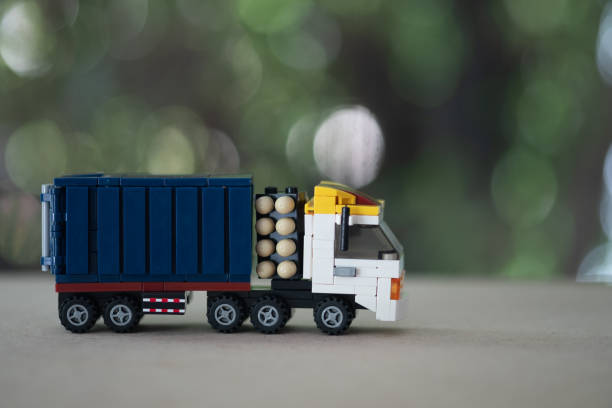 Toy miniature truck on a wooden table. using as transportation and logistic concept Toy miniature truck on a wooden table. using as transportation and logistic concept car transporter truck small car stock pictures, royalty-free photos & images