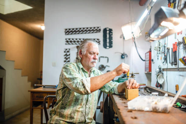 istock Mature Man Using Screwdriver for Repairs in Home Workshop 1224152871