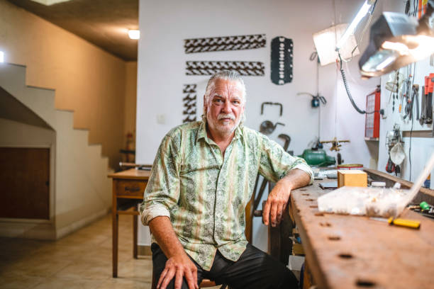 istock Mature Man Making Repairs at Workbench in Home Basement 1224152996