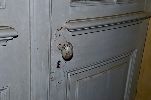 A beautiful old door handle on a white door