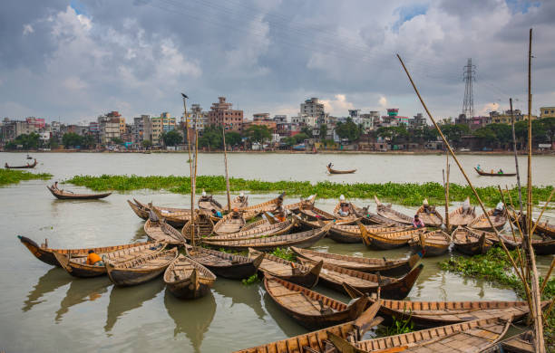 Bunch of river crossing passenger boat in Buriganga River. All boats stands here in a circular way for repairing & cleaning. This photo was taken from Kamrangirchar area near Dhaka city. bangladesh photos stock pictures, royalty-free photos & images