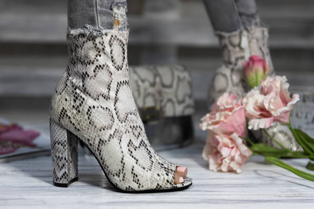 sapatos de salto alto femininos de luxo feitos de pele de cobra usado por uma mulher - street style - fotografias e filmes do acervo
