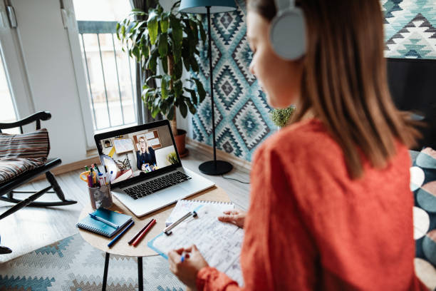 istock Rear view of student with focus on professor on laptop during online class 1224154626