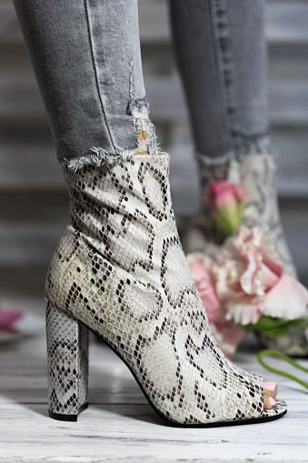 Luxury female high heel shoes made from snake skin worn by a woman