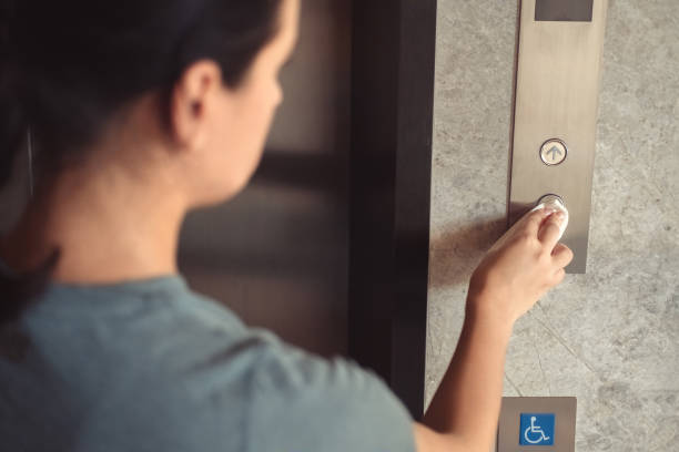 istock Woman pressing elevator button through tissue paper. Infection prevention and control of Corona virus Covid-19 epidemic 1224155580