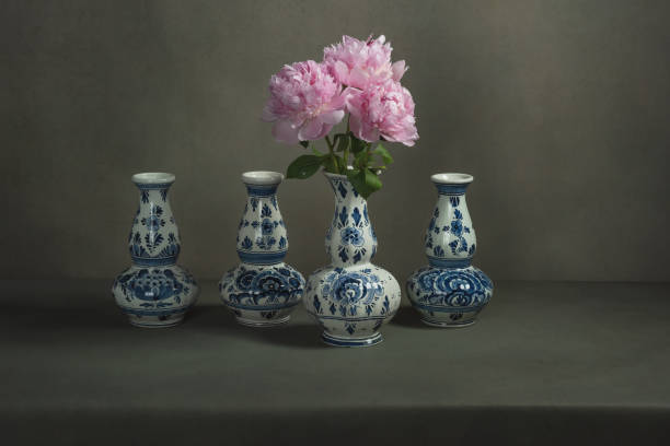 istock Four delft blue vases with peonies in one on a table in a grey room. 1224157094