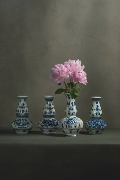 istock Four delft blue vases with peonies in one on a table in a grey room. 1224157106