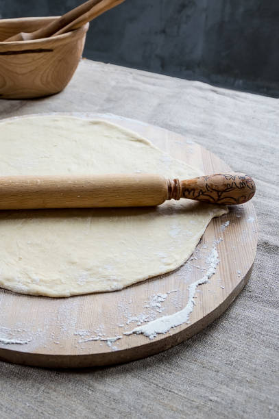 istock Wheat flour dough for making dumplings or pizza on a wooden Board with a rolling pin. 1224157591