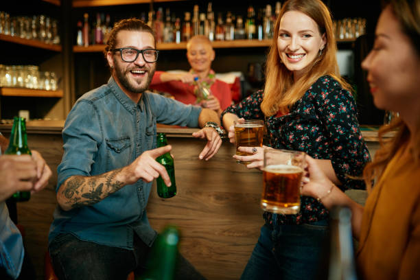 istock Group of friends drinking beer, chatting and having gun at pub. 1224157625