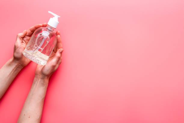 istock Sanitizer bottle in hands - coronavirus prevention - on pink background top view copy space 1224159202