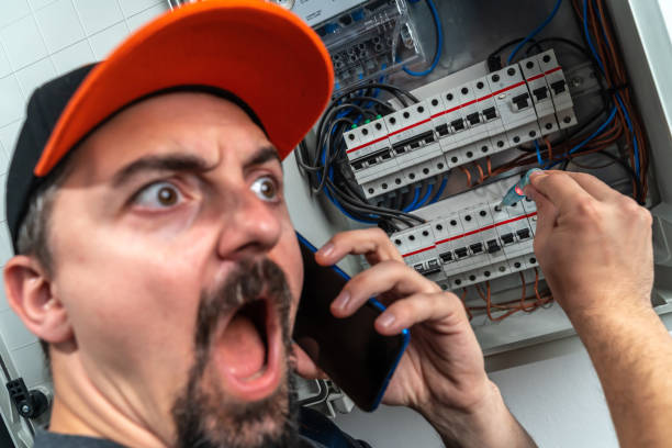 istock Funny electrician checking fuse box and use smart phone 1224160575