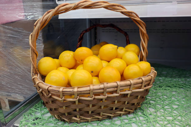 limones amarillos en una cesta - wicker basket store gift shop fotografías e imágenes de stock