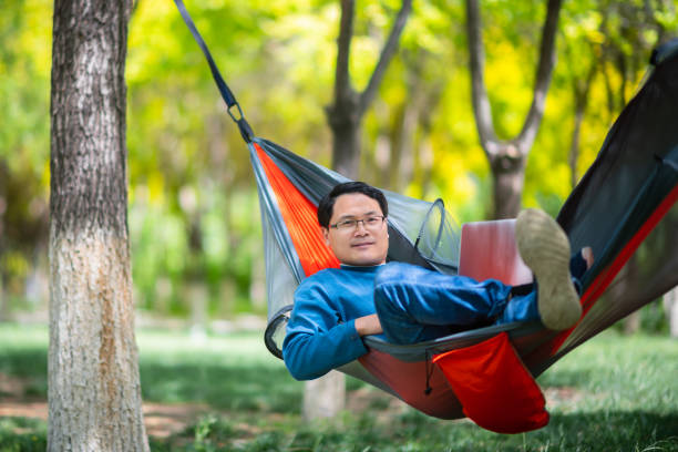 istock Asian men relaxing in hammocks and watching laptops 1224168456