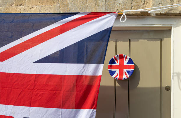 Union Jack Flag paper plate hanging from a door outside an old Cotswold house to celebrate  the 75th anniversary Victory in Europe’ VE celebrations. Union Jack Flag paper plate hanging from a door outside an old Cotswold house to celebrate  the 75th anniversary Victory in Europe’ VE celebrations. ve day celebrations uk stock pictures, royalty-free photos & images