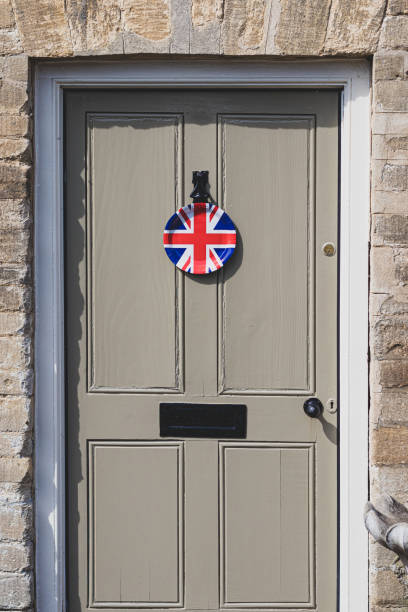 Union Jack Flag paper plate hanging from a door outside an old Cotswold house to celebrate  the 75th anniversary Victory in Europe’ VE celebratio Union Jack Flag paper plate hanging from a door outside an old Cotswold house to celebrate  the 75th anniversary Victory in Europe’ VE celebrations. ve day celebrations uk stock pictures, royalty-free photos & images