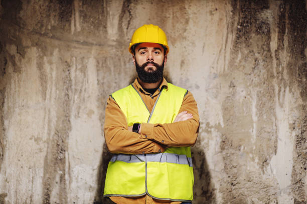 istock Young bearded worker standing at construction site with arms crossed. 1224169348