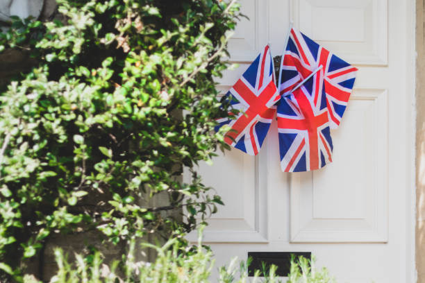 Union Jack Flags hanging from a door outside an old house to celebrate  the 75th anniversary Victory in Europe’ VE celebrations.