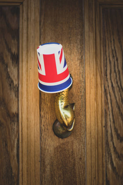 Union Jack Flag paper cup hanging from a door knocker outside an old Cotswold house to celebrate  the 75th anniversary Victory in Europe’ VE celebrations.