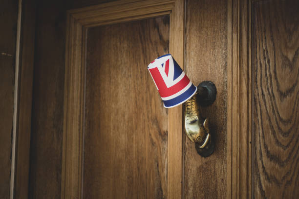 Union Jack Flag paper cup hanging from a door knocker outside an old Cotswold house to celebrate  the 75th anniversary Victory in Europe’ VE celebrations. Union Jack Flag paper cup hanging from a door knocker outside an old Cotswold house to celebrate  the 75th anniversary Victory in Europe’ VE celebrations. ve day celebrations uk stock pictures, royalty-free photos & images