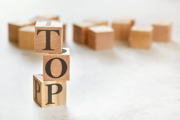 istock Three wooden cubes with word TOP, on white table, more in background, space for text in right down corner 1224170104