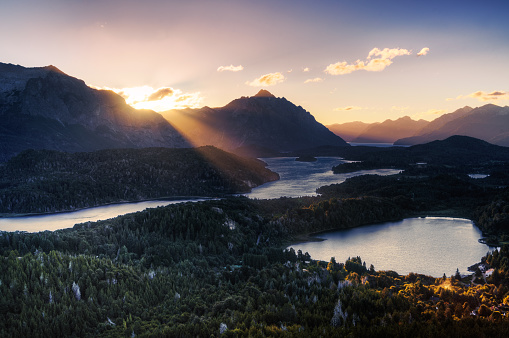 Sunbeam illuminating a lake through a mountain