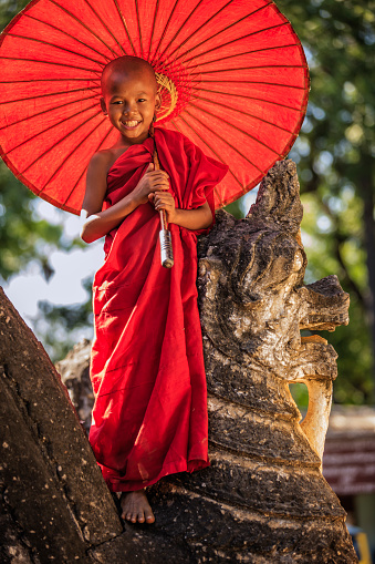 Young Buddhist monk posing on one of ancient temples in Bagan, Myanmar (Burma)