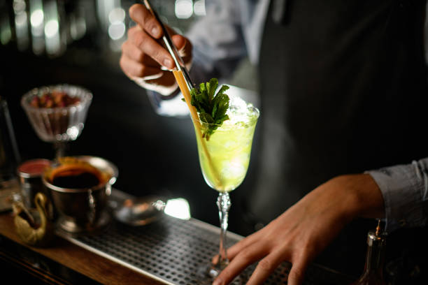 istock bartender carefully decorates by mint green alcoholic drink with ice in glass. 1224171415