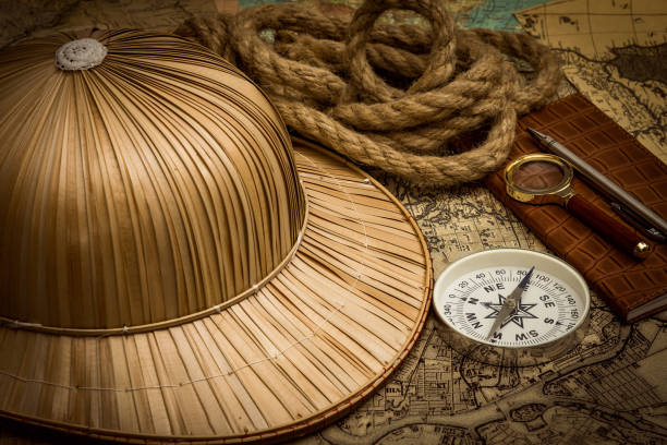 helmet on the background of an old colonial map with a compass for exploring the travel route