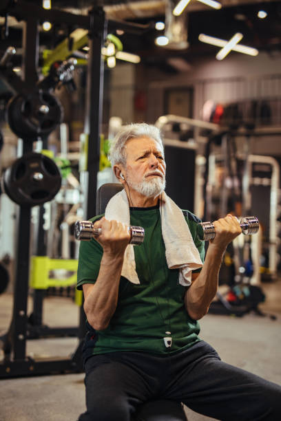 istock Senior man working out with dumbbells at the gym 1224172273