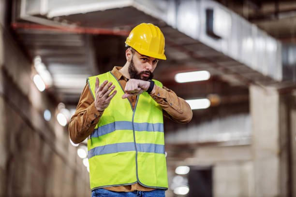 istock Dedicated bearded supervisor standing in underground garage in construction process and talking with investors over smart watch. 1224172397
