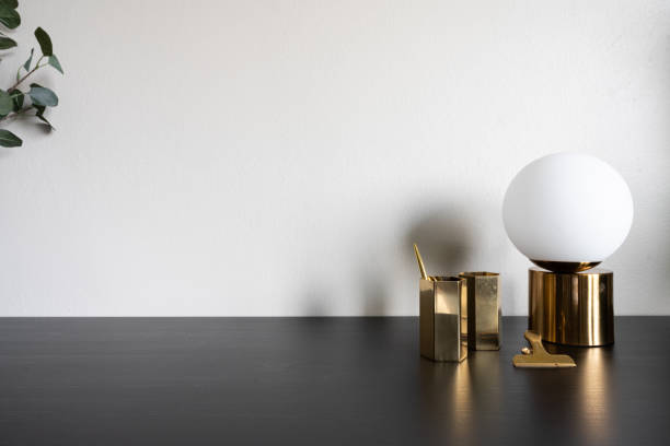 istock Isolated gold mirror hexagon stainless vase and gold mirror circular table lamp setting on black wood table top and beige color background / object isolated / background / copy space interior decoration 1224172677