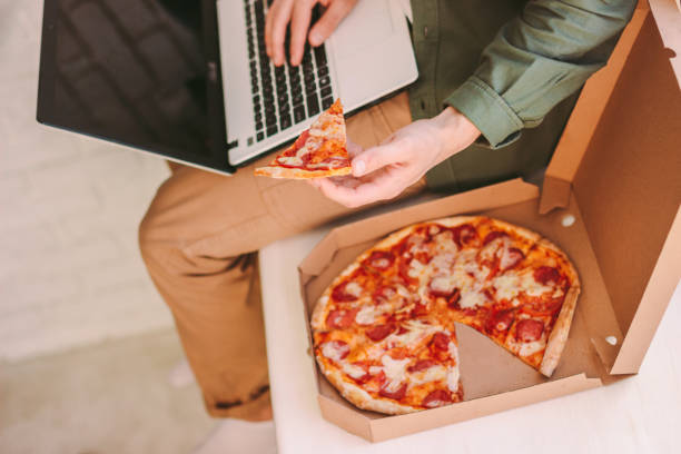 istock Hungry hipster businessman freelancer having lunch break, while work at home 1224175832