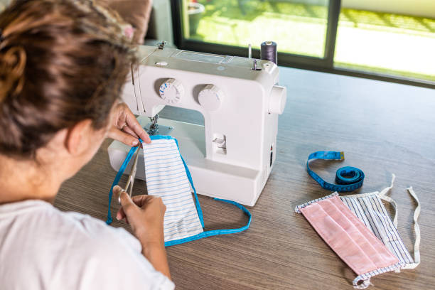 istock Woman making face masks with a sewing machine at home 1224179092