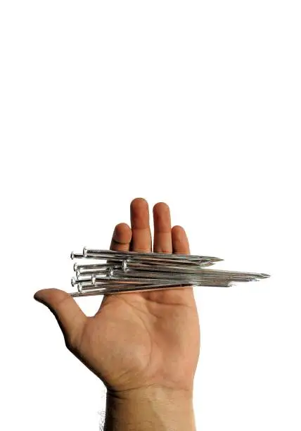 Hand holding steel nails on white background. construction concept
