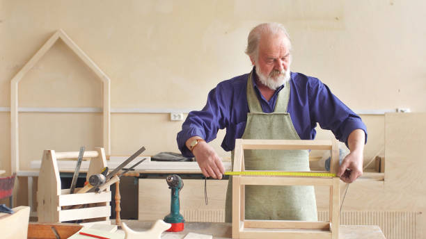 istock gray- Haired man by profession a carpenter working in his workshop 1224181781