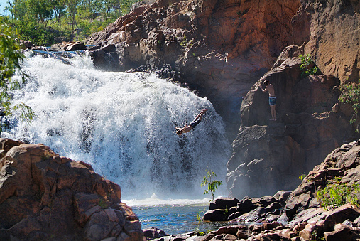 Australia, unidentified youth jumping into Edith Falls in Northern Territory