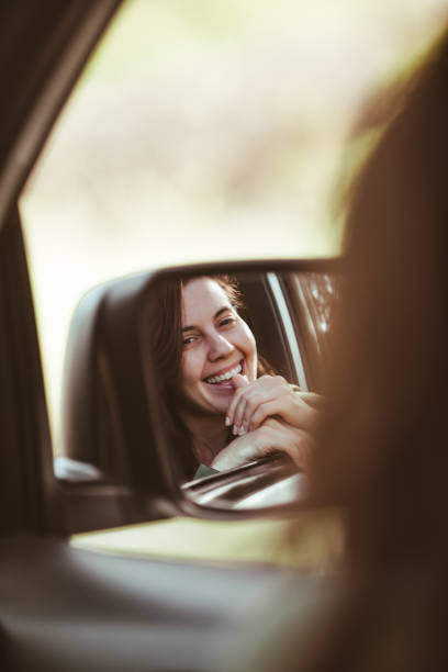 istock reflection on stunning smiling woman in car rear mirror 1224183273
