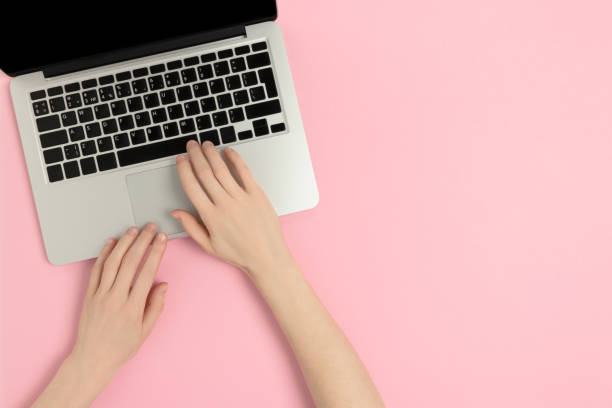 istock Female hands typing on laptop. Workspace concept on a pink pastel background. 1224183607