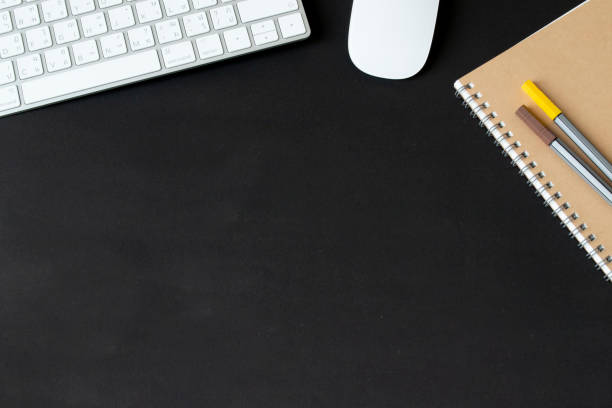 istock Modern black office desk table with keyboard and mouse and other supplies with Blank notebook page for input the text in the middle. Top view, flat lay. 1224184139