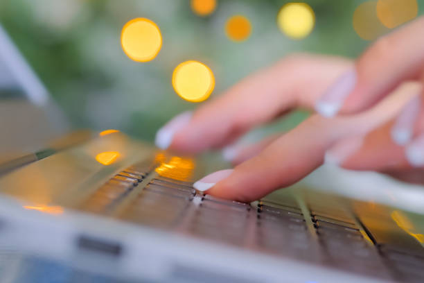 istock Woman typing on laptop computer keyboard with bokeh light background - close up 1224185332