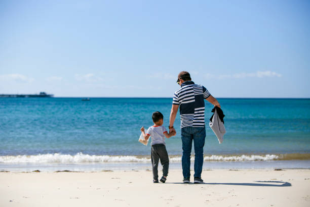 istock dad and sons playing together on the beach 1224185395