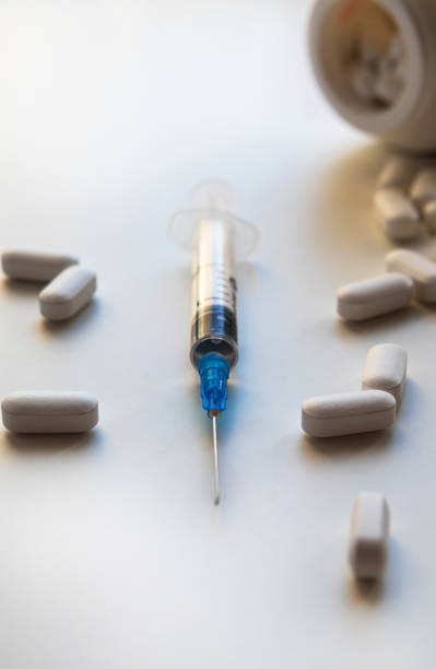 istock Syringe on white background with white pills. medicine theme . Selective focus. 1224185406