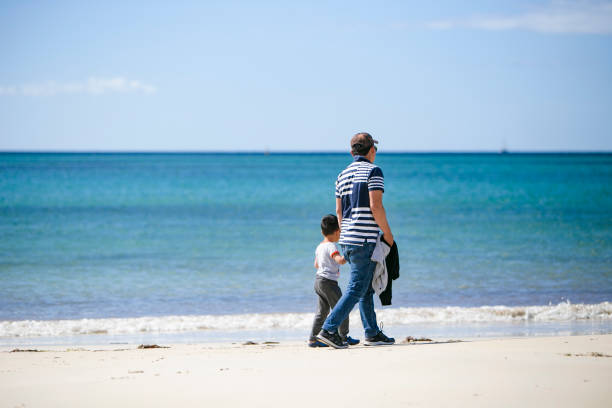 istock dad and sons playing together on the beach 1224186339