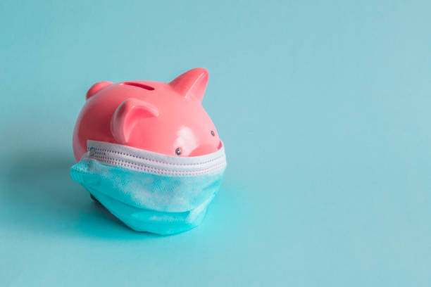 Piggy bank with protective face mask on isolated background stock photo
