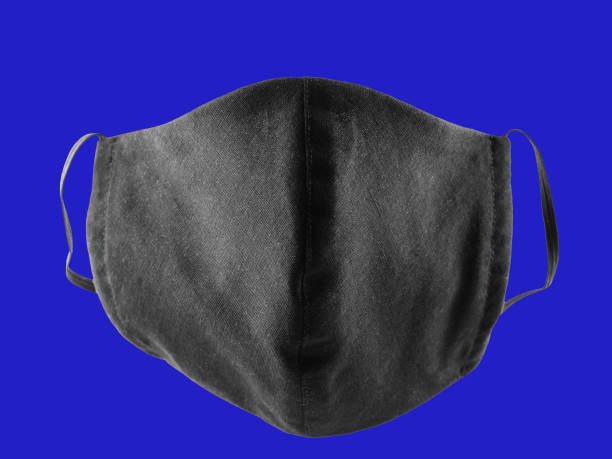 istock Protective mask pop art. Antivirus mask made from cotton. Black stylish face mask during a pandemic virus COVID-19. Face protective mask on a classic blue background 1224190764