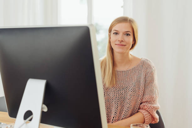 istock Young blonde woman sitting in front of computer 1224193914
